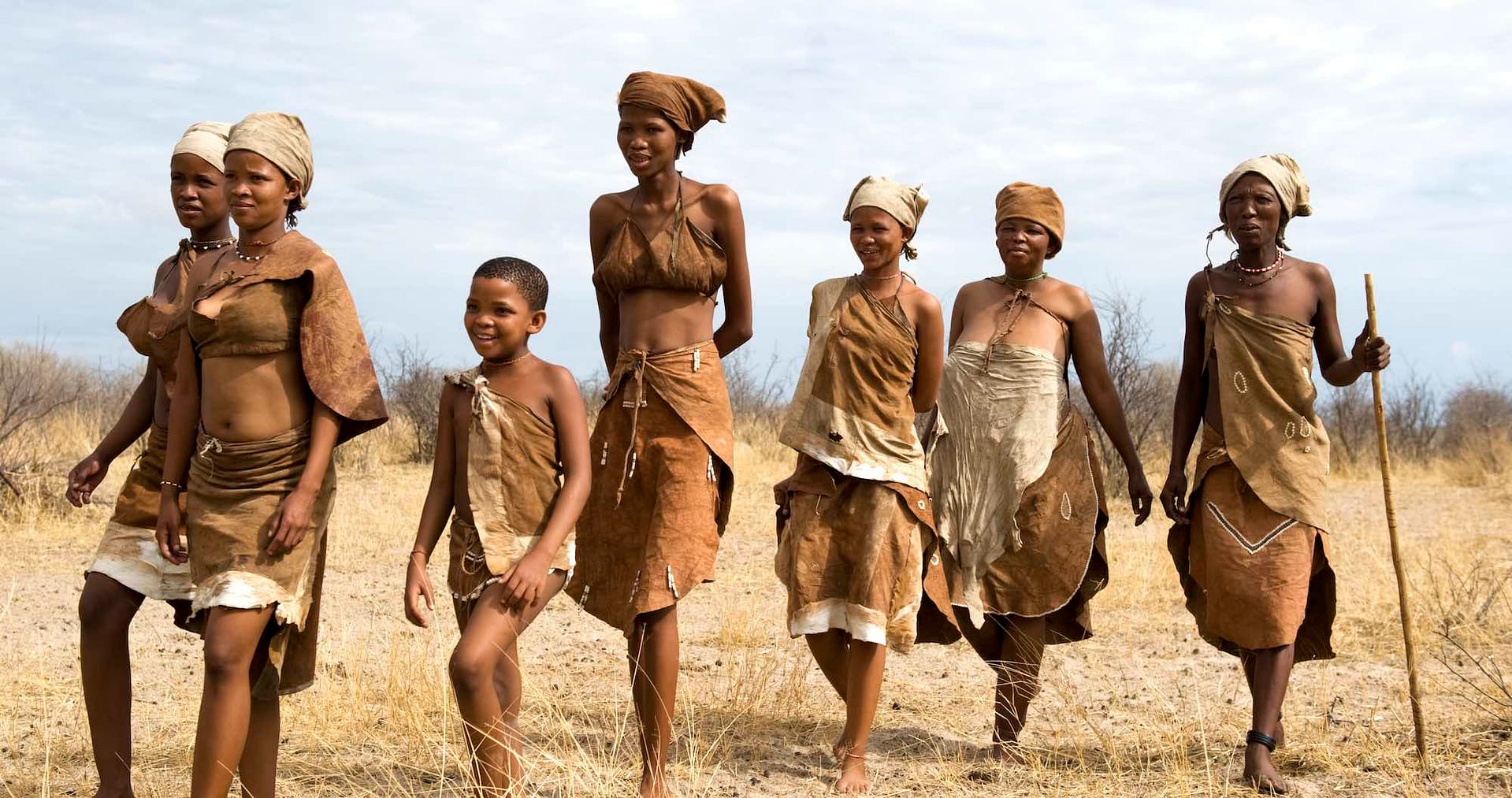 A group of seven happy looking San people.